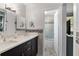 Modern bathroom featuring a double vanity with sleek cabinets, countertops, stylish mirrors, and a separate shower area at 9900 Ne 20 Terrace Rd, Anthony, FL 32617