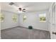 Bright bedroom with three windows, gray carpet, and ceiling fan at 9900 Ne 20 Terrace Rd, Anthony, FL 32617