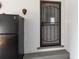 A secure door with security gate and a black fridge sits in this white-brick house at 9900 Ne 20 Terrace Rd, Anthony, FL 32617