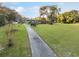 Aerial view of the long driveway leading up to the residence, surrounded by green grass at 9900 Ne 20 Terrace Rd, Anthony, FL 32617