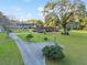 Large lot showcasing red brick home, long driveway, gazebo, mature trees, and lush green lawn at 9900 Ne 20 Terrace Rd, Anthony, FL 32617