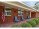 Welcoming front porch with classic blue Adirondack chairs, red brick, and fresh landscaping at 9900 Ne 20 Terrace Rd, Anthony, FL 32617