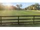 A sprawling front yard is enclosed by a quaint fence and trees with Spanish moss at 9900 Ne 20 Terrace Rd, Anthony, FL 32617