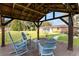 Gazebo interior featuring Adirondack chairs overlooking the yard, and red brick home at 9900 Ne 20 Terrace Rd, Anthony, FL 32617