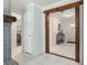Hallway showcasing a decorative wooden beam, white tile flooring, and a view into the entryway at 9900 Ne 20 Terrace Rd, Anthony, FL 32617