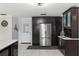 A spacious kitchen boasts modern appliances and dark wood cabinetry with a white tile floor at 9900 Ne 20 Terrace Rd, Anthony, FL 32617