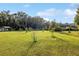 Large grassy yard with various saplings and other plantings at 9900 Ne 20 Terrace Rd, Anthony, FL 32617