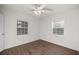 Cozy bedroom featuring modern wood-look flooring, a ceiling fan, and two windows for ample natural light at 1309 Ne 33Rd St, Ocala, FL 34479