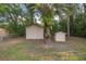 Two sheds in a fenced yard, with a palm tree, offer extra storage and match the home's exterior at 1309 Ne 33Rd St, Ocala, FL 34479