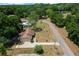 An aerial view of a home in a quiet neighborhood surrounded by lush greenery and mature trees with a long driveway at 164 Ne 53Rd St, Ocala, FL 34479