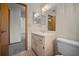 The bathroom showcases a single sink vanity, large mirror, toilet, and a doorway to hallway at 164 Ne 53Rd St, Ocala, FL 34479