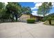 The property features a concrete driveway leading to an attached garage surrounded by well maintained shrubs and trees at 164 Ne 53Rd St, Ocala, FL 34479