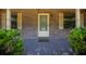Charming brick home entrance with a white front door, decorative shutters, and manicured bushes at 164 Ne 53Rd St, Ocala, FL 34479