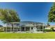 The large backyard features a screened-in pool area, lush green lawn and mature trees at 1763 Sw 155Th Place Rd, Ocala, FL 34473