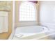 Bright bathroom with a large soaking tub and a large arched window at 1763 Sw 155Th Place Rd, Ocala, FL 34473