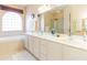 Bright bathroom with a large soaking tub, double vanity with marble countertops, and a large window at 1763 Sw 155Th Place Rd, Ocala, FL 34473