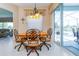 Bright breakfast nook featuring a round wood table and ornate metal chairs, adjacent to a screened patio at 1763 Sw 155Th Place Rd, Ocala, FL 34473