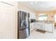 A bright kitchen with white cabinets, modern appliances, and an archway to a breakfast nook at 1763 Sw 155Th Place Rd, Ocala, FL 34473