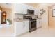 Kitchen featuring white cabinets, stainless steel appliances, and decorative wall art at 1763 Sw 155Th Place Rd, Ocala, FL 34473