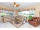Bright living room featuring comfortable couches, large windows, and a ceiling fan at 1763 Sw 155Th Place Rd, Ocala, FL 34473