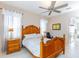 Spacious bedroom with wooden furnishings, ceiling fan, and ensuite bathroom access at 1763 Sw 155Th Place Rd, Ocala, FL 34473