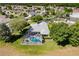 Aerial view of backyard pool with screened enclosure, surrounded by lush green landscaping in a residential neighborhood at 1763 Sw 155Th Place Rd, Ocala, FL 34473