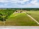 Broad aerial perspective showing a property with abundant green fields, mature trees, and a lengthy driveway leading to a serene homesite at 22111 Obrien Rd, Howey In The Hills, FL 34737