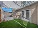 Private covered patio with synthetic grass, pavers, white doors, and stylish string lights for outdoor living at 2343 Se 19Th Cir, Ocala, FL 34471