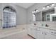 Bathroom featuring a double vanity and tiled tub at 2369 Nw 53Rd Avenue Road, Ocala, FL 34482