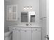 Well-lit bathroom features a white vanity with marble countertop and a window with white shutters at 2369 Nw 53Rd Avenue Road, Ocala, FL 34482