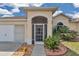 Close-up of front door with screened entryway, landscaping, and stucco exterior at 2369 Nw 53Rd Avenue Road, Ocala, FL 34482