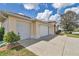Close-up of a two-car garage with white doors and light-colored stucco exterior, plus landscaped yard at 2369 Nw 53Rd Avenue Road, Ocala, FL 34482