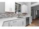 Kitchen boasts stainless steel appliances, white cabinetry, and tile backsplash at 2369 Nw 53Rd Avenue Road, Ocala, FL 34482