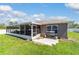 View of home with covered patio, landscaped yard, and a grill for outdoor entertaining at 2689 Sw 165Th Street Rd, Ocala, FL 34473