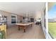 A long covered patio has a pool table, tile floor and seating area, creating an inviting space at 2689 Sw 165Th Street Rd, Ocala, FL 34473