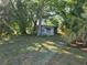 The backyard with a shed, lawn, and tall trees providing natural shade at 2818 Ne 25Th Ct, Ocala, FL 34470