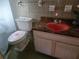Bathroom with tile floor and tile walls, unique red sink, toilet, and shower at 2818 Ne 25Th Ct, Ocala, FL 34470