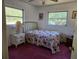 Bedroom featuring two windows, floral themed bedding and carpet at 2818 Ne 25Th Ct, Ocala, FL 34470