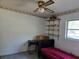 Bedroom featuring rose themed wall border with a ceiling fan, a desk and single bed at 2818 Ne 25Th Ct, Ocala, FL 34470