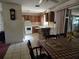 Traditional kitchen with wood cabinets, white appliances, and a breakfast bar open to the dining area at 2818 Ne 25Th Ct, Ocala, FL 34470