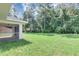 A large green backyard has a covered patio and backs up to a treeline at 3 Redwood Track Run, Ocala, FL 34472