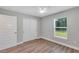 Empty bedroom featuring laminate flooring, window and a sliding door closet at 3 Redwood Track Run, Ocala, FL 34472