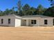New construction featuring white siding, gray roof, and tidy landscaping on a sunny day at 3 Redwood Track Run, Ocala, FL 34472