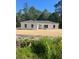 An exterior of new construction with white siding and a gray roof, surrounded by lush greenery at 3 Redwood Track Run, Ocala, FL 34472