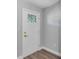 Front door with geometric glass detail, contrasting hardware and wood-look flooring at 3 Redwood Track Run, Ocala, FL 34472