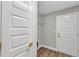 Hallway with luxury flooring and white doors with gold handles at 3 Redwood Track Run, Ocala, FL 34472