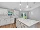 Bright kitchen featuring quartz countertops, stainless appliances, an island, and backyard views at 3 Redwood Track Run, Ocala, FL 34472