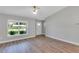 Bright living room with modern ceiling fan, wood-look floors and natural light from the front window at 3 Redwood Track Run, Ocala, FL 34472