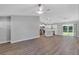 Open-concept living space with wood-look floors, gray walls, and an adjacent kitchen with stainless steel appliances at 3 Redwood Track Run, Ocala, FL 34472