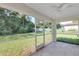 The screened patio has views of the green yard and trees in the distance at 3 Redwood Track Run, Ocala, FL 34472